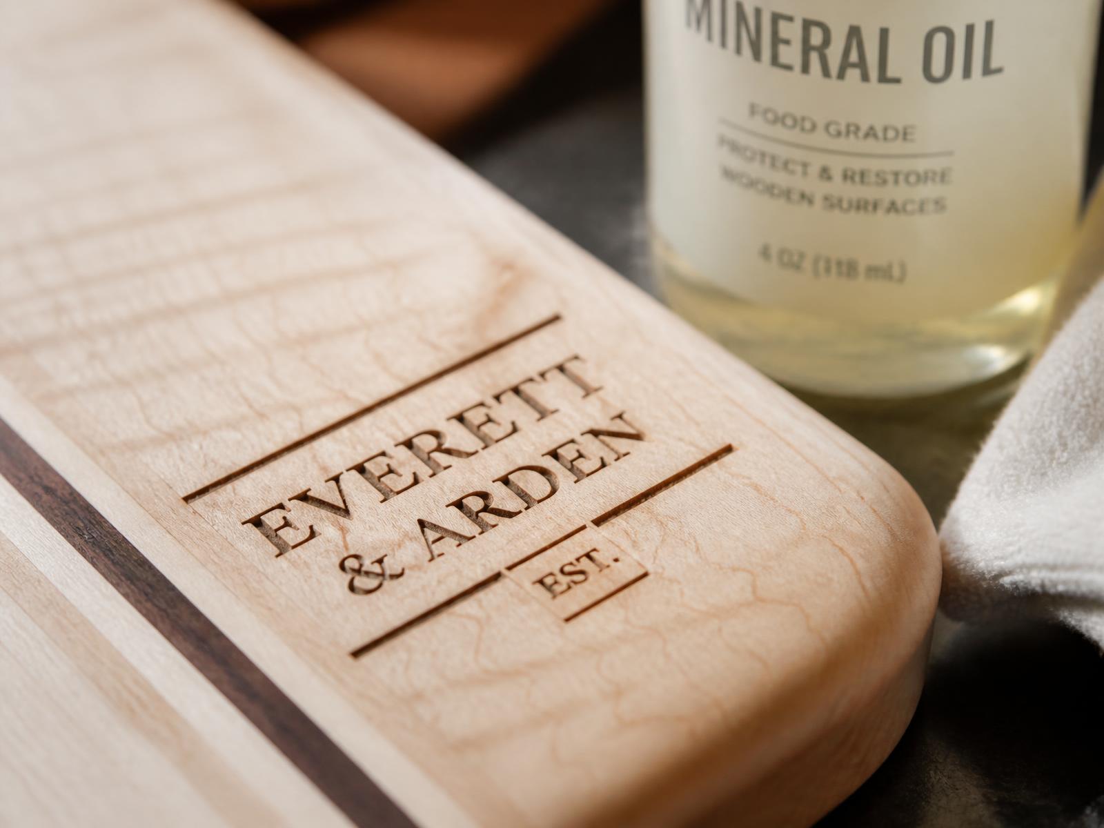 Macro close-up of laser-engraved lettering in the grain of a maple custom cutting board