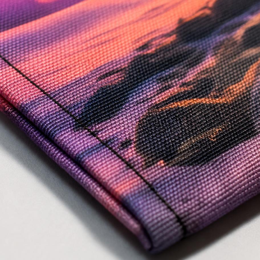 Close-up of dye-sublimated tapestry fabric showing print detail and a stitched hem edge