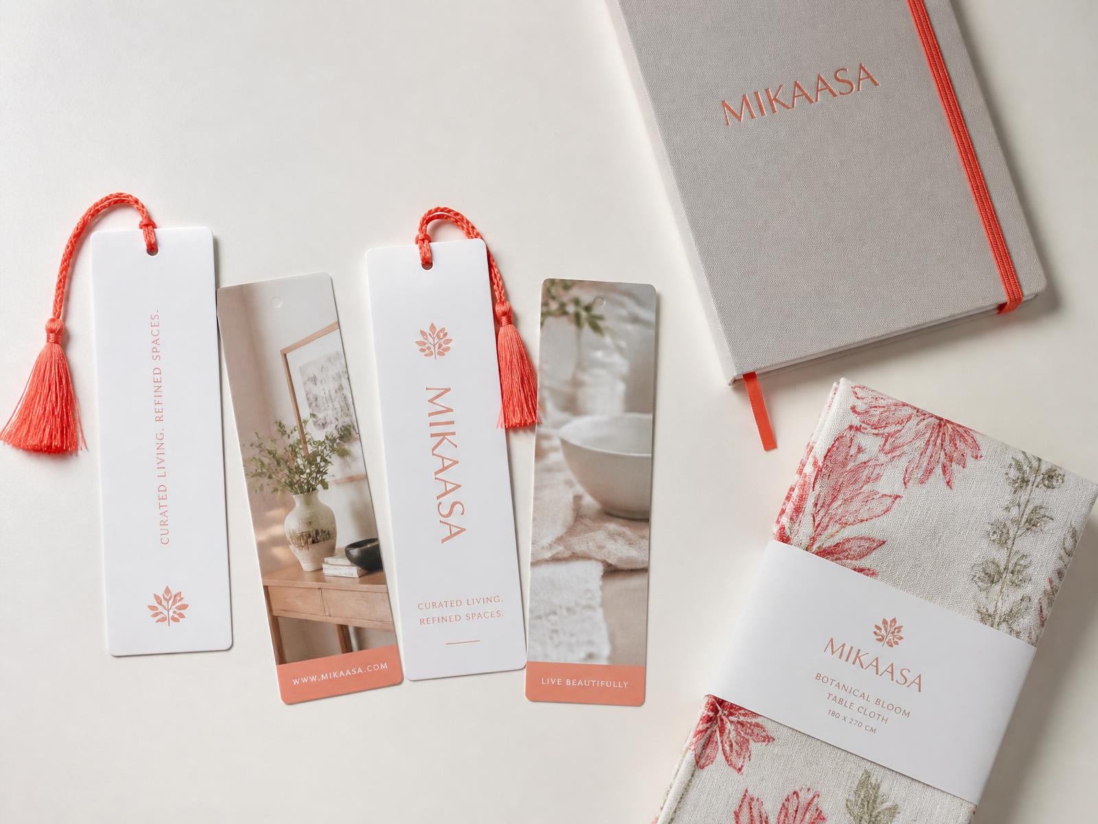 Branded promo flat lay with custom bookmarks, a notebook, and a folded table cloth swatch