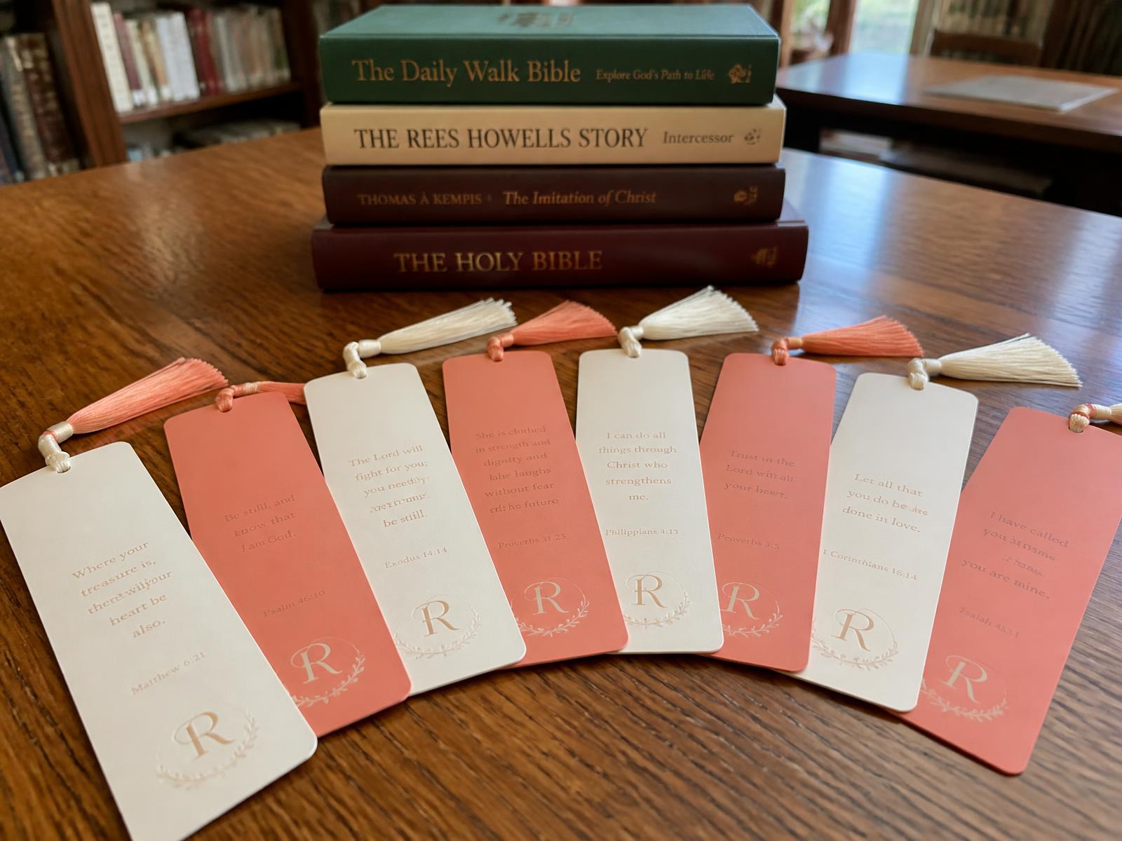 Custom bookmarks with tassels fanned out across a wooden library table
